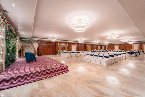 a large banquet hall with white tables and blue chairs at Playotel Resort Bhopal in Bhopal