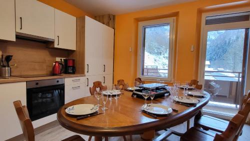 - une cuisine avec une table en bois et des verres à vin dans l'établissement Le Bouquetin, à Entremont