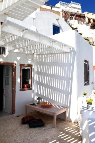 a white wall with a wooden table in a patio at Menias Cave House in Oia
