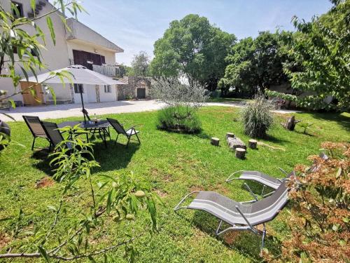 a yard with chairs and a table in the grass at Ferienwohnung für 6 Personen ca 90 qm in Mrgani, Istrien Istrische Riviera in Mrgani