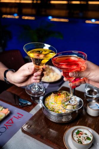 a group of people holding up drinks on a table at Playotel Resort Bhopal in Bhopal