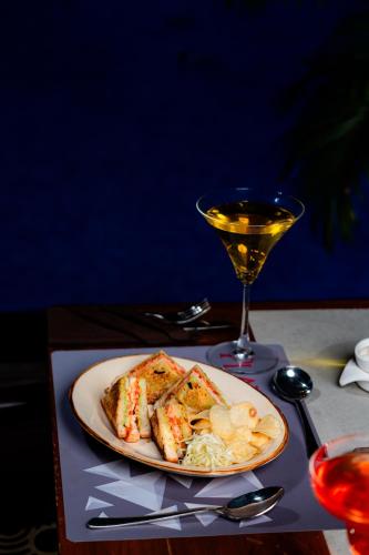 a plate of food and a glass of wine on a table at Playotel Resort Bhopal in Bhopal