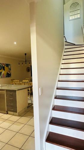 a staircase leading up to a kitchen and a living room at Santana's Getaway in Agnes Water