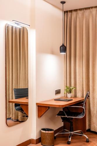 an office with a desk and a chair and a mirror at Playotel Resort Bhopal in Bhopal