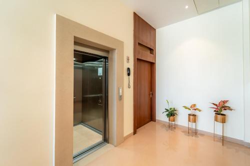 a hallway with a glass door and two plants at Playotel Resort Bhopal in Bhopal