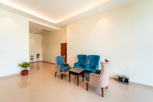 a waiting room with blue chairs and a table at Playotel Resort Bhopal in Bhopal