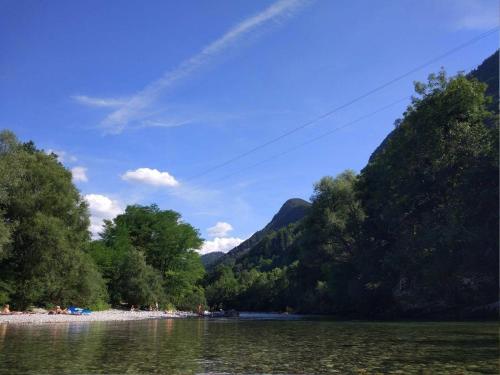 vistas a un río con árboles y una montaña en Ferienwohnung für 4 Personen ca 72 qm in Slap ob Idrijci, Küstenland Slowenien en Slap ob Idrijci