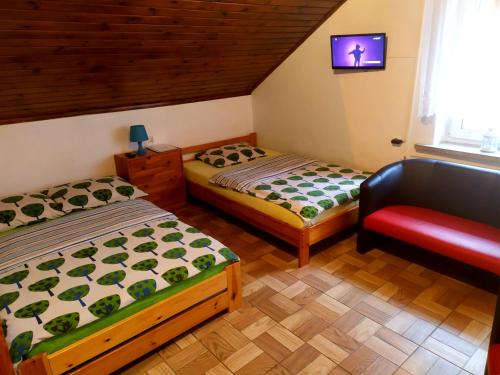 a room with two beds and a chair in it at Noclegi Relax in Ruciane-Nida