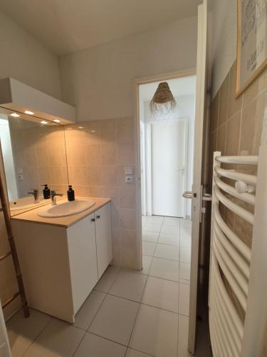 une petite salle de bain avec un lavabo et un miroir dans l'établissement Le Bordelou, 6-8 pers, heated pool, à Lacanau-Océan