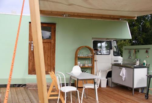 霍尔斯泰因地区诺伊斯塔特Marilyn - Glamping im Mercedes DüDo auf Camping Seeblick的一个带桌椅的庭院和一间厨房