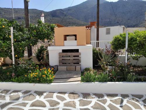 a garden with a fireplace with a mountain in the background at Katerina's House in Sitia