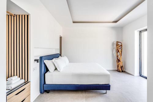 a bedroom with a blue bed in a white room at Suite San Montano by Feeling Italy in Massa Lubrense