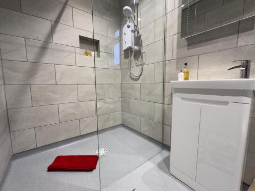 y baño con ducha y toalla roja. en The Kyrenia en Weston-super-Mare