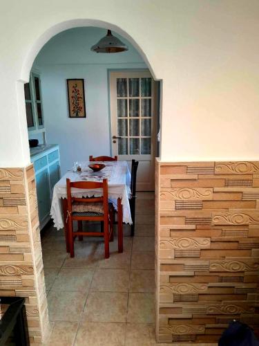 a dining room with a table and a kitchen at Katerina's House in Sitia