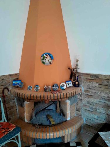 a brick fireplace with clocks on top of it at Katerina's House in Sitia