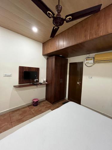 HOTEL VAANI CONTINENTAL في كانبور: غرفة نوم بسرير ومروحة سقف