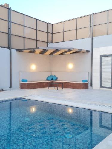 a large swimming pool with blue water in a building at Jimi Chalet in Al Kafrayn