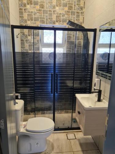 a bathroom with a toilet and a sink at Jimi Chalet in Al Kafrayn