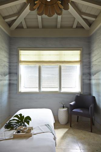 a bedroom with a bed and a window and a chair at The Island House in Nassau