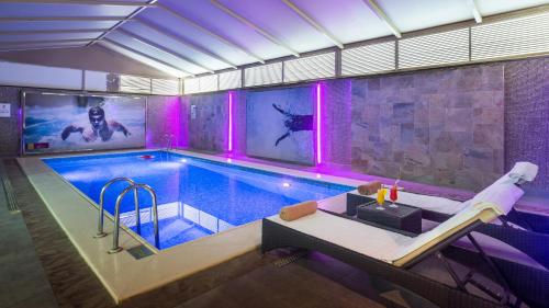 فندق نوفوتيل سويتس الرياض عليا في الرياض: حمام سباحة مع أضواء أرجوانية في مبنى