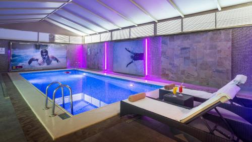 a swimming pool with purple lights in a building at Novotel Suites Riyadh Olaya in Riyadh