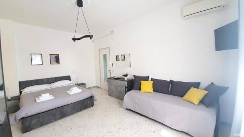 a bedroom with two beds and a couch at Limited Edition Guesthouse in Bari
