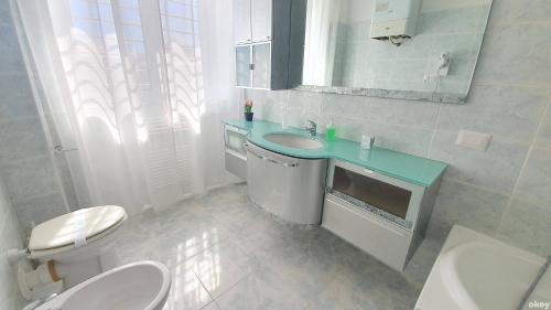 uma casa de banho com um lavatório, um WC e um espelho. em Limited Edition Guesthouse em Bari