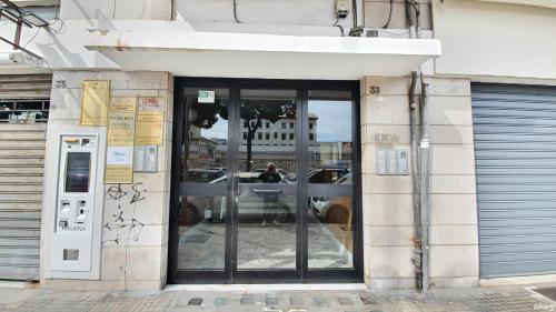 a glass door of a building with a person in it at Limited Edition Guesthouse in Bari
