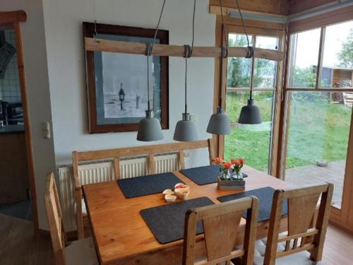 a wooden table with chairs and a dining room at Kuckucksnest - Ferienwohnung Welschneudorf in Welschneudorf