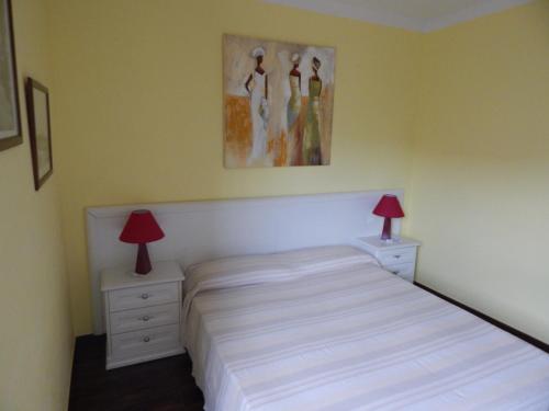 1 dormitorio con 1 cama y 2 mesitas de noche con lámparas en Il Melograno, en Albenga