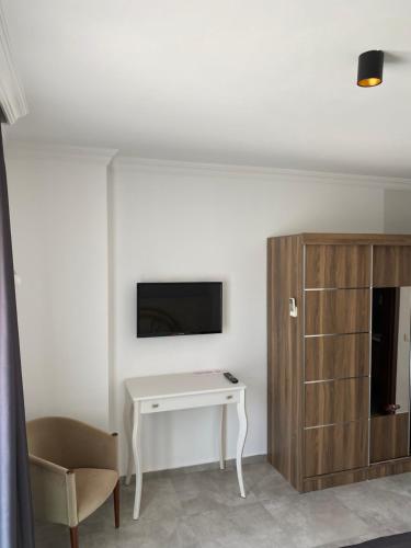 a living room with a tv and a table and a desk at Orya Aparts in Gümbet