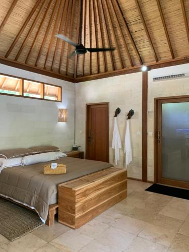 een slaapkamer met een bed en een plafondventilator bij Kubu Shanti in Gili Meno