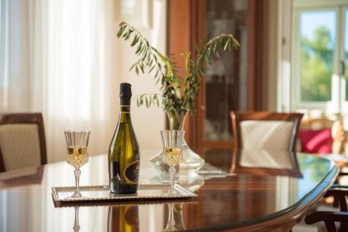 een fles wijn en twee glazen op een tafel bij Ferienhaus mit Privatpool für 8 Personen ca 210 qm in Trget, Istrien Bucht von Raša in Trget