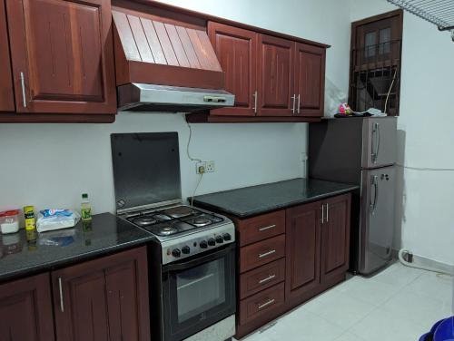 uma cozinha com armários de madeira e um forno com placa de fogão em Homestay relax and enjoy em Sri Jayewardenepur- Kotte