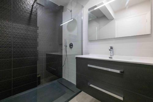 łazienka z przeszkloną kabiną prysznicową i umywalką w obiekcie Somptueux appartement 20m plages avec vue mer w mieście Antibes