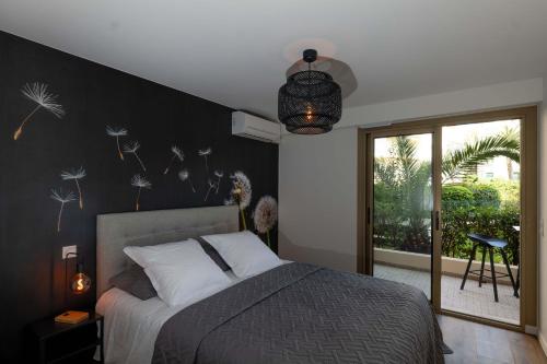 sypialnia z łóżkiem z czarną ścianą w obiekcie Somptueux appartement 20m plages avec vue mer w mieście Antibes
