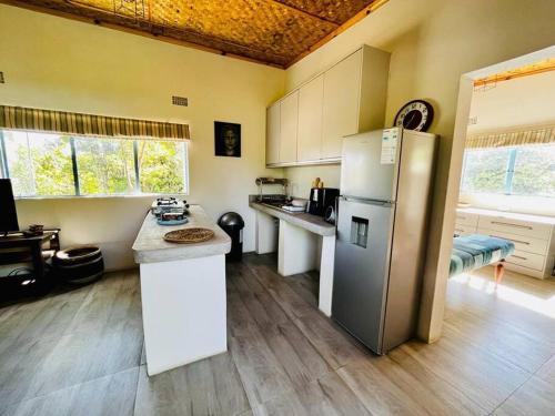 a kitchen with a refrigerator and a counter top at Charming Cottage in the wilderness on 5 Acres in Lusaka