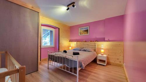 - une chambre aux murs violets et un lit dans un dortoir dans l'établissement La marmotte, à Entremont