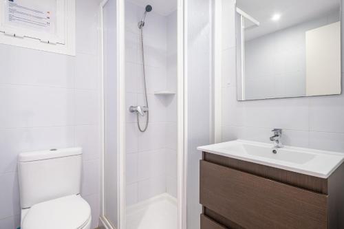 a white bathroom with a toilet and a sink at Los Ranchos 1-3 Apartment Levante Beach in Benidorm