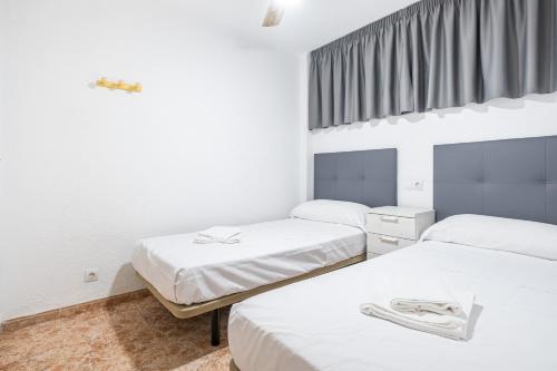 2 camas en una habitación con paredes blancas y ventana en Los Ranchos 1-3 Apartment Levante Beach, en Benidorm
