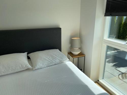 a bed with a black headboard and a window at CPH Like Home in Copenhagen