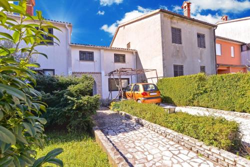 um carro laranja estacionado em frente a um edifício em Ferienwohnung für 8 Personen ca 160 qm in Fažana, Istrien Istrische Riviera em Valbandon