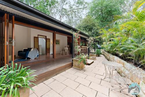 a house with a wooden porch with a patio at Aircabin - Warrawee - Sydney - 5 Beds House in Warrawee