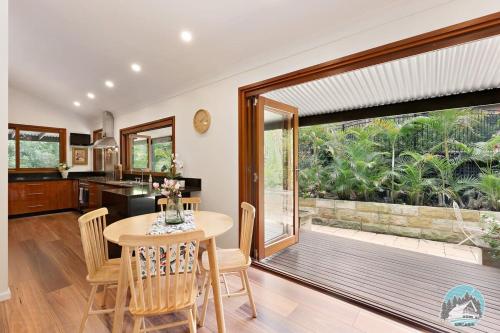 a kitchen and dining room with a table and a large window at Aircabin - Warrawee - Sydney - 5 Beds House in Warrawee