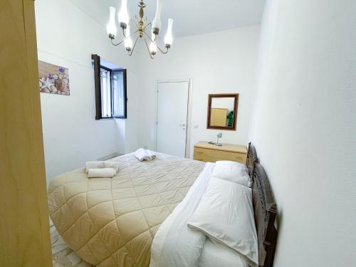 a bedroom with a bed and a chandelier at """ Holiday Properties Sicilian Central """ in Avola