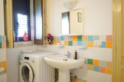 a bathroom with a sink and a washing machine at """ Holiday Properties Sicilian Central """ in Avola