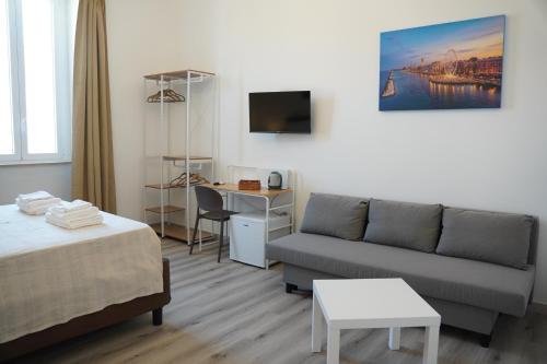 - un salon avec un lit et un canapé dans l'établissement BARI VICA ROOMS, à Bari