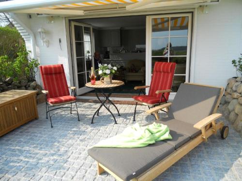 - une terrasse avec deux chaises, un lit et une table dans l'établissement Ferienwohnung für 2 Personen ca 55 qm in Munkmarsch, Nordfriesische Inseln Sylt - a87454, à Munkmarsch