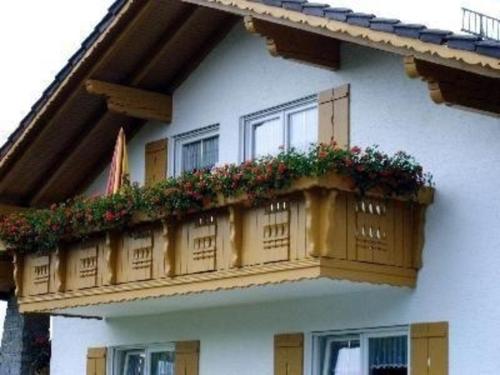 un edificio con un balcón con flores. en Ferienwohnung für 5 Personen ca 80 qm in Regen, Bayern Bayerischer Wald, en Regen