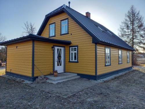 a small yellow house with a black roof at Privacy within city limits in Tartu
